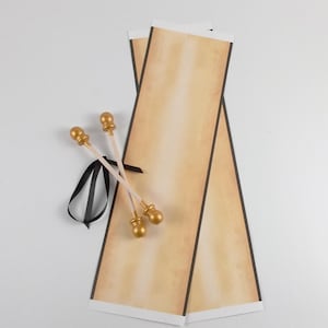 vintage style scroll kit with unassembled paper, gold finials, and black ribbon.