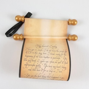 vintage style paper scroll with text, gold finials, and black ribbon.