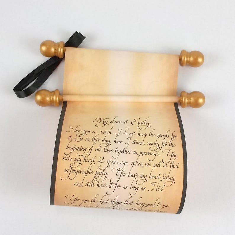 vintage style paper scroll with text, gold finials, and black ribbon.