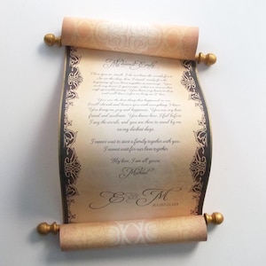 May include: A scroll with a brown and gold design. The scroll is unfurled and the text reads "My dearest Emily, I love you so much. I do not have the words for... I cannot wait to start a family together with you. I cannot wait for our lives together. My love, I am all yours, Michael. E & M 10.20.2023."