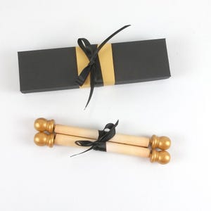 vintage style scroll with gold finials and black ribbon. includes a black gift box with paper band and ribbon.