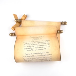 May include: A tan parchment scroll with dark brown cursive text titled Letter to my husband Michael, featuring gold-colored finials on the ends of the wooden rods and a gold ribbon tied to the top left side of the rolled paper document.