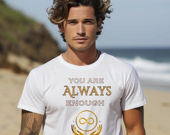 Könnte beinhalten: Weißes T-Shirt mit dem goldenen Schriftzug "YOU ARE ALWAYS ENOUGH". Das Design beinhaltet ein Unendlichkeitssymbol und goldene Hände. Das T-Shirt wird von einer Person am Strand getragen.