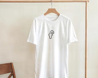 May include: A white short-sleeved t-shirt featuring a simple black outline of the lowercase letter f centered on the chest. The garment is displayed on a wooden hanger suspended from a wooden rack, showcasing a clean and basic design.