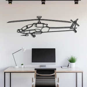 May include: Black metal helicopter wall art. The artwork depicts a detailed outline of a helicopter, including the rotor blades and tail rotor. The helicopter is mounted on a white wall above a desk with a computer monitor, lamp, and small plant.