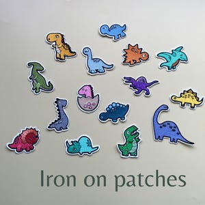 May include: A set of 14 iron-on patches featuring colourful cartoon dinosaurs in various poses. The patches are perfect for adding a fun and whimsical touch to clothing, bags, or other fabric items.