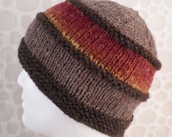 May include: A hand-knitted beanie hat in shades of brown, with a central band of red, orange, and yellow. The hat features a ribbed brim and a textured knit pattern, perfect for cold weather.