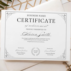 以下が含まれることがあります： 装飾的なシルバーのボーダーとテキストが入った白い証明書。「CERTIFICATE of achievement」と書かれており、「Aaron Smith」に贈られます。会社名、署名、テキスト「AWARD 20XX」が含まれています。
