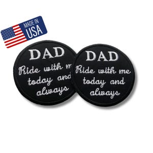 Puede incluir: Dos parches circulares bordados en negro con texto blanco que dice DAD Ride with me today and always. Una pequeña etiqueta rectangular en la esquina superior izquierda muestra la bandera estadounidense y el texto MADE IN USA en letras blancas.