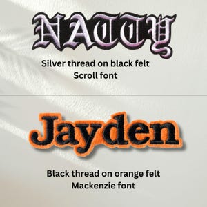 Puede incluir: Dos parches bordados con nombres. El parche superior muestra el texto NATTY en hilo plateado sobre fieltro negro con una fuente de estilo pergamino. El parche inferior muestra el texto Jayden en hilo negro sobre fieltro naranja con fuente Mackenzie.