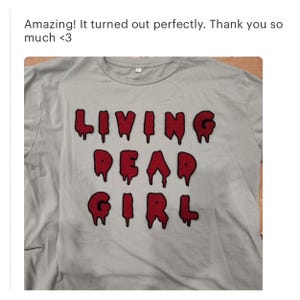 May include: A light blue t-shirt with the words "LIVING DEAD GIRL" in red dripping letters.