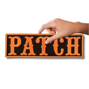 Puede incluir: Un parche rectangular negro con el texto "PATCH" bordado en naranja.