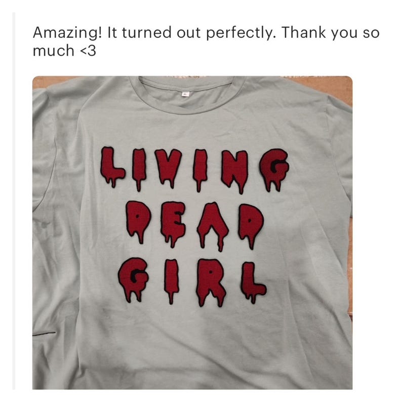 May include: A light blue t-shirt with the words "LIVING DEAD GIRL" in red dripping letters.