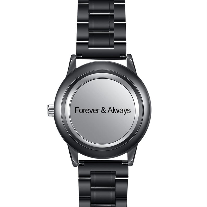 May include: A black metal wristwatch with a round case and a matching link bracelet. The watch face is a solid, smooth light gray circle featuring the black text Forever & Always centered in the middle. A small silver crown is on the left side.