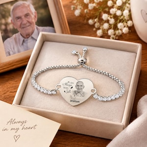 Könnte beinhalten: Ein silberfarbenes, verstellbares Armband mit einem herzförmigen Anhänger, der das Porträt eines älteren Mannes, den Text "I Am Always With You" und den Namen "William" zeigt. Das Armband ist mit klaren, funkelnden Steinen besetzt.