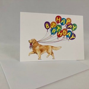 May include: A greeting card featuring a golden retriever dog holding a bouquet of flowers and pulling a string of colorful balloons that spell out "Happy Birthday".
