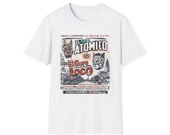 May include: White t-shirt featuring a vintage wrestling poster design. The graphic includes the words "El Perro Atomico" versus "El Gato Loco" with additional text about the event, including the date and location.
