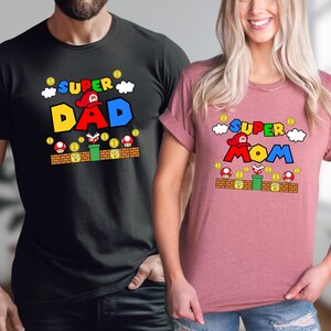 A man and a woman are standing next to each other, both wearing t-shirts with the same design.