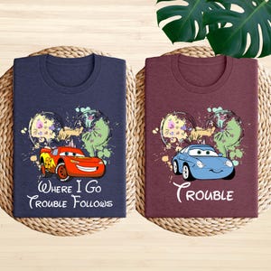 two t-shirts with the same design, including cartoon cars and the text "Where I Go, Trouble Follows".