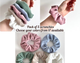 Può includere: Un pacchetto di cinque scrunchies in velluto di diversi colori, tra cui rosa, blu, verde, beige e bianco. Pack of 5 scrunchies Choose your colors from 17 available