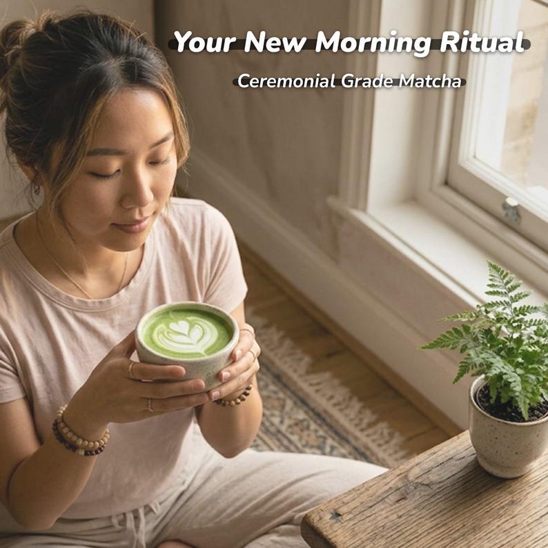 May include: A person holding a ceramic bowl of green matcha tea with a heart design. The text "Your New Morning Ritual" and "Ceremonial Grade Matcha" are displayed above the bowl. A small potted fern sits on a wooden table.