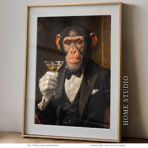 May include: A framed art print featuring a chimpanzee dressed in a black tuxedo, white shirt, and white gloves, holding a martini glass with an olive. The text HOME STUDIO is printed vertically on the right side of the white matting.