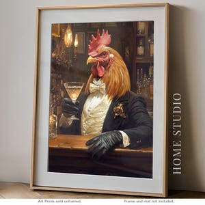 May include: Framed art print featuring a rooster in a tuxedo holding a martini glass. The rooster is depicted in a bar setting, wearing a white bow tie and black gloves. The print has the text "HOME STUDIO" on the right side.