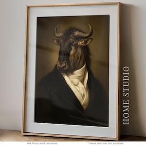 May include: A framed art print featuring a portrait of a wildebeest with horns, dressed in a dark coat and a white cravat. The image includes the text HOME STUDIO vertically on the right side and Art Prints sold unframed. Frame and mat not included.