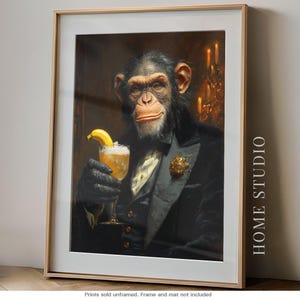 May include: A framed wall art print featuring a chimpanzee dressed in a black tuxedo with a white shirt and gold lapel pin. The chimpanzee holds a glass containing a yellow liquid with a banana slice garnish. The text HOME STUDIO is visible.