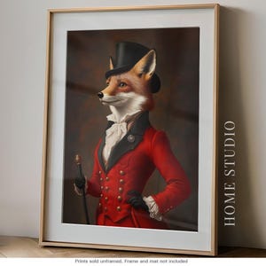 May include: A framed wall art print featuring a fox dressed in a black top hat, a red tailcoat with gold buttons, and a white ruffled cravat. The fox holds a walking stick and wears black gloves. The text HOME STUDIO is printed on the right side.
