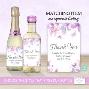 Op de afbeelding: Twee paarse en witte bedanklabels met vlinders en bloemenmotieven voor een babyshower. De labels zeggen "Bedankt Cassie & Jonathan's Baby Shower 04.27.20xx".