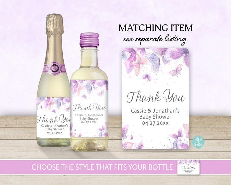 Op de afbeelding: Twee paarse en witte bedanklabels met vlinders en bloemenmotieven voor een babyshower. De labels zeggen "Bedankt Cassie & Jonathan's Baby Shower 04.27.20xx".