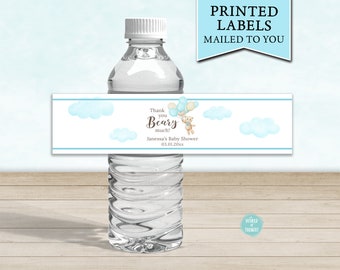 May include: Water bottle label with a blue and white watercolor design featuring a teddy bear holding balloons. The label says "Thank you Beary much!" and "Janessa's Baby Shower 03.01.20xx".