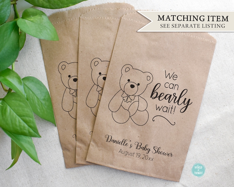 Puede incluir: Tres bolsas de papel marr&oacute;n con un dise&ntilde;o de osito de peluche y el texto "We can bearly wait!"  Danielle's Baby Shower August 19, 20xx