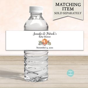 May include: Water bottle label with a fall theme. The label is white with black text that reads "Jennifer & Patrick's Baby Shower" and "November 9, 20xx". There is a watercolor illustration of a pumpkin with leaves and berries.