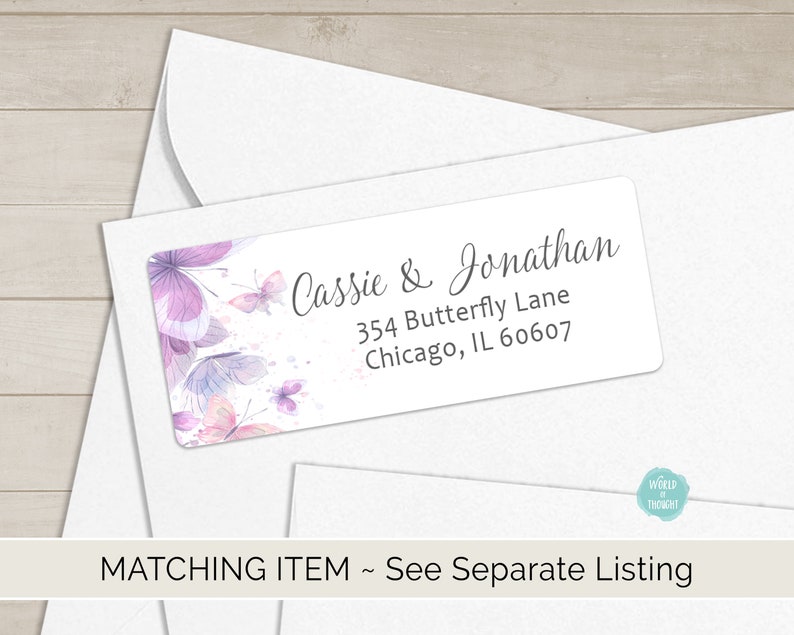 Op de afbeelding: Een witte envelop met een retouradreslabel met een aquarelontwerp van paarse vlinders en de tekst "Cassie & Jonathan, 354 Butterfly Lane, Chicago, IL 60607".