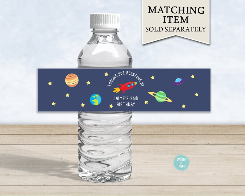Op de afbeelding: Waterfleslabel met een blauwe achtergrond en sterren. Het label zegt "Bedankt voor het meevieren van Jaime's 2e verjaardag" met een raket, planeten en een UFO.