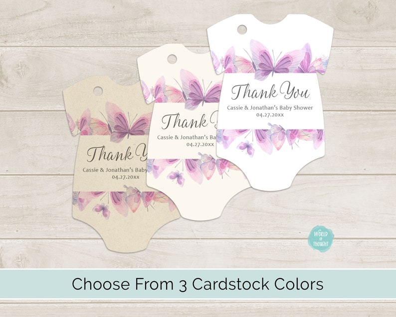 Op de afbeelding: Drie baby-rompertjes in de vorm van bedankkaartjes met een aquarel-vlinderontwerp in tinten paars en roze. De tekst op de kaartjes luidt "Bedankt" met de naam "Baby Shower van Cassie & Jonathan" en de datum "04.27.20xx".