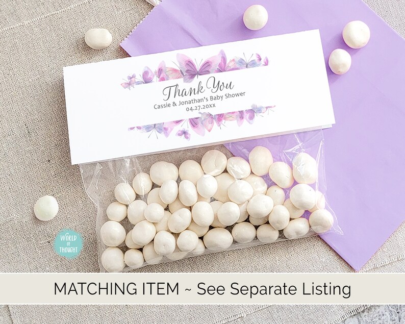 Op de afbeelding: Een witte cadeauzak met een wit bedankkaartje. Het kaartje heeft een paars aquarel vlinderontwerp en de tekst "Thank You Cassie & Jonathan's Baby Shower 04-27-20xx".