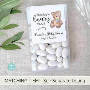 Puede incluir: Un recipiente de pl&aacute;stico transparente lleno de mentas blancas. Una etiqueta blanca con una ilustraci&oacute;n de un oso de peluche marr&oacute;n y el texto "Thank you beary much! Danielle's Baby Shower August 19, 20xx" est&aacute; pegada al recipiente.