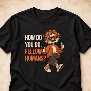 May include: A black t-shirt featuring a graphic of a robot with orange hair, sunglasses, and a mustache, wearing an orange cardigan and dark pants. The robot is giving a thumbs up with both hands. The text reads: HOW DO YOU DO, FELLOW HUMANS?