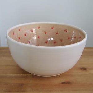 Misa na owoce w kształcie serca z ceramiki, duża, ziemista orchidea i biała ceramiczna miska do serwowania