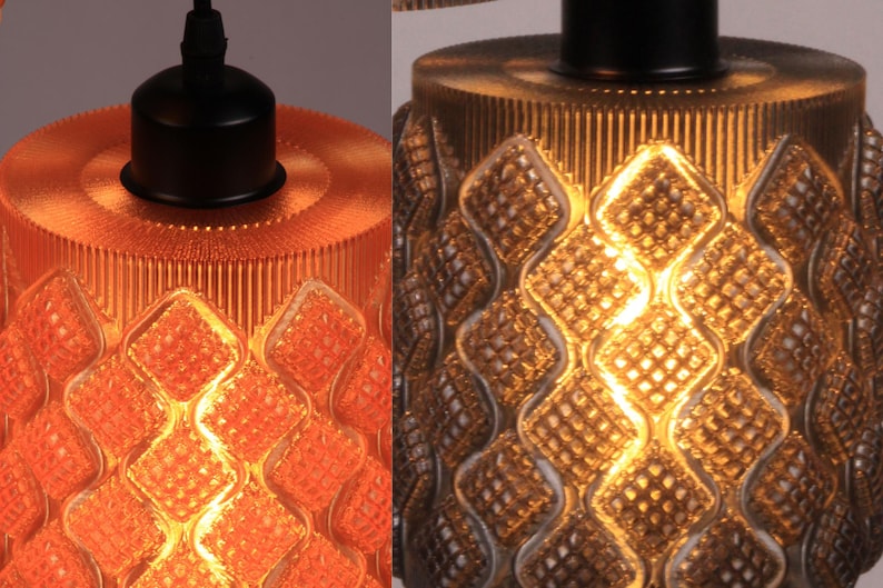 May include: Close-up of two pendant lights with textured glass shades. One is orange, the other is gold. Both have a diamond pattern and a black fixture. The lights are designed for indoor use.
