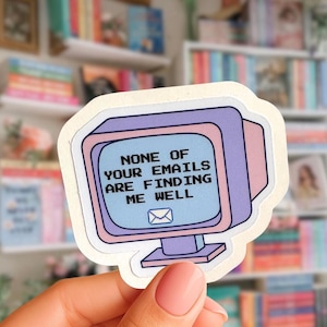 May include: A die-cut sticker shaped like a vintage computer monitor with a light blue screen displaying the black pixelated text NONE OF YOUR EMAILS ARE FINDING ME WELL and a small envelope icon. The monitor casing is purple and light pink.
