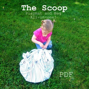 May include: A young child is playing with a striped playmat and bag. The playmat is folded up and the child is holding it in their hands. The text "The Scoop Playmat and Bag All-in-one! PDF" is visible in the image.