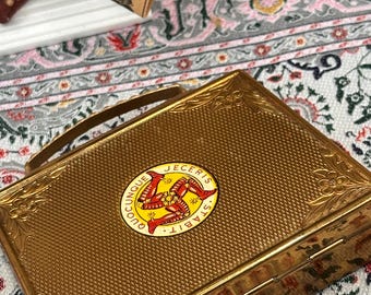 Estuche de polvos musical vintage con mascota – Maleta Triskelion de la Isla de Man, recuerdo de tocador (años 50)