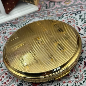 Polvera Stratton vintage en tono dorado / con acabado guilloché, fabricada en Inglaterra