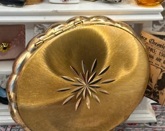 Estuche de maquillaje vintage Kigu Concerto con polvera musical y acabado dorado torneado.