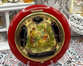 Estojo de pó compacto francês em celuloide vermelho, vintage, com cena Art Déco, 7,5 cm, item de colecionador.