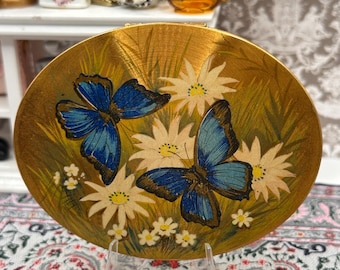 Polvos compactos vintage con forma de mariposa y margarita, espejo ovalado en tono dorado, diseño de mediados de siglo.